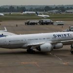 A United Airlines Boeing 787-9 Dreamliner parked at Gate B44 of London Heathrow Airport, surrounded by emergency vehicles and ground crew after an emergency diversion.