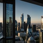 A vibrant cityscape of London with modern skyscrapers under a bright sky, symbolizing economic growth and business optimism in the UK.