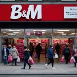 Exterior view of a B&M discount store in a UK town, with signage and customers entering.