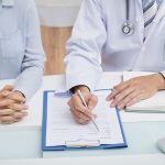 A healthcare professional filling a patient’s confidential medical history