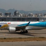 Air Busan airplane on tarmac with a "No Power Banks" sign in the foreground, highlighting the airline's groundbreaking safety policy announced on August 31, 2025.
