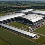 Aerial view of Rolls-Royce's sprawling Derby manufacturing facility in the UK, showcasing advanced engineering hubs against a backdrop of green fields, symbolizing innovation in aerospace and defence.