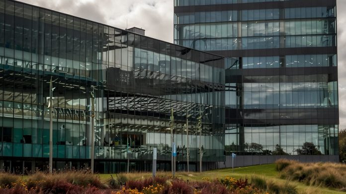 Modern AstraZeneca headquarters building in Cambridge, UK, overlaid with a rising stock chart reflecting a 4.2% share price surge on October 2, 2025, after cancer drug approval.