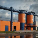 Exterior of AG Barr’s modern production facility in Cumbernauld, Scotland, with prominent Irn-Bru branding and sleek industrial design.