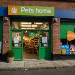 Vibrant exterior of a Pets at Home store in Manchester, UK, with colorful signage and pet-related displays welcoming customers.