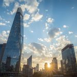 Striking view of Barclays headquarters in London's Canary Wharf financial district with modern skyscrapers and business professionals, depicting the bank's profit resilience and share price surge amid monetary easing prospects for 2025