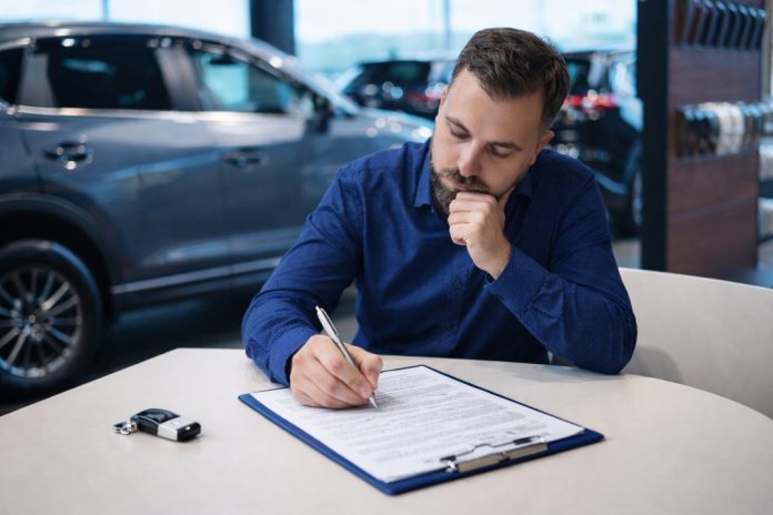 Driver reviewing car finance paperwork on a laptop at home