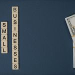 Dollar bills beside letter tiles spelling small businesses