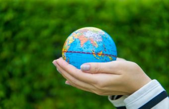 A hand holding a globe representing global business and international communication