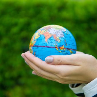 A hand holding a globe representing global business and international communication