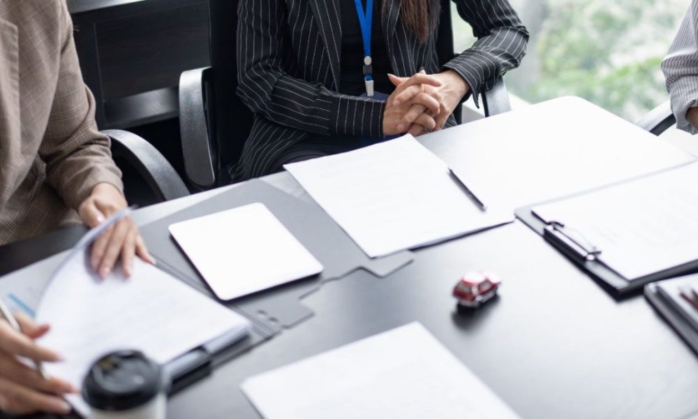 Buyers reviewing vendor documents at a retail category meeting, illustrating the vendor packet a retailer reads