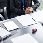 Buyers reviewing vendor documents at a retail category meeting, illustrating the vendor packet a retailer reads