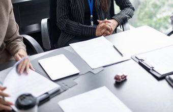 Buyers reviewing vendor documents at a retail category meeting, illustrating the vendor packet a retailer reads