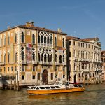 Historic palazzi lining the Grand Canal in Venice as a water bus passes