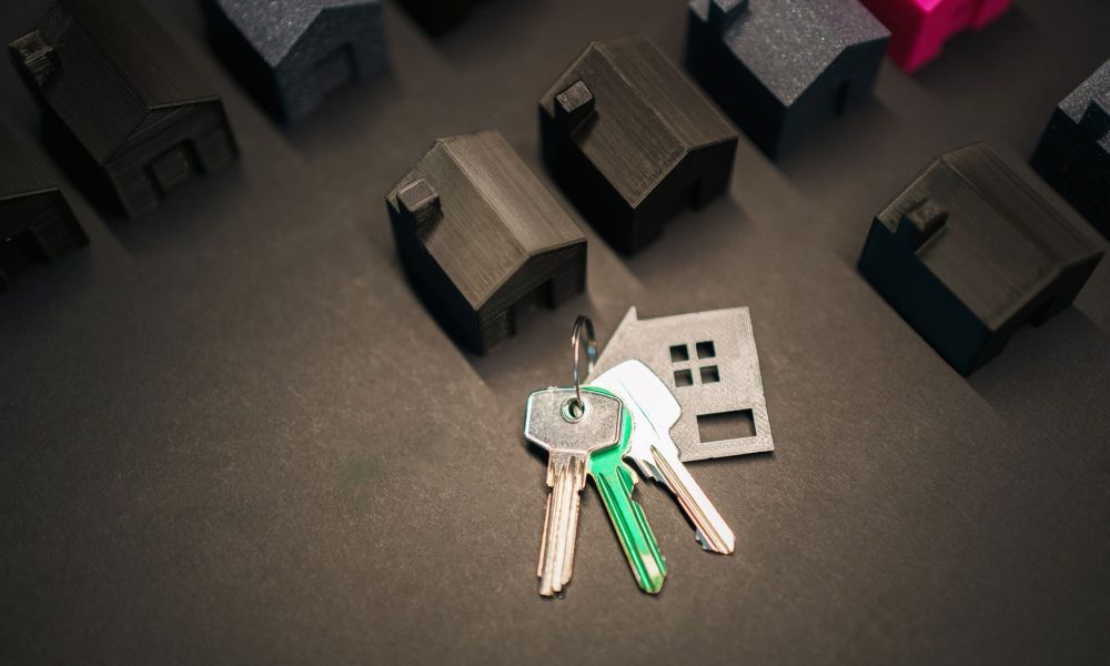 Miniature house models and keys symbolize real estate investment and housing market.