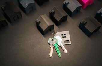 Miniature house models and keys symbolize real estate investment and housing market.
