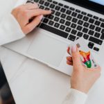 A person holding a credit card while shopping online on a laptop