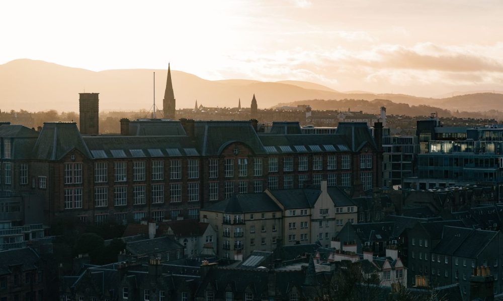 A historic city skyline with hills at sunrise