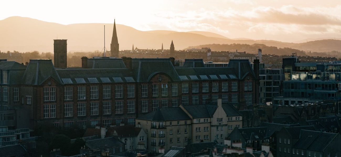 A historic city skyline with hills at sunrise