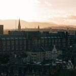 A historic city skyline with hills at sunrise