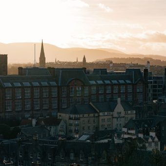 A historic city skyline with hills at sunrise