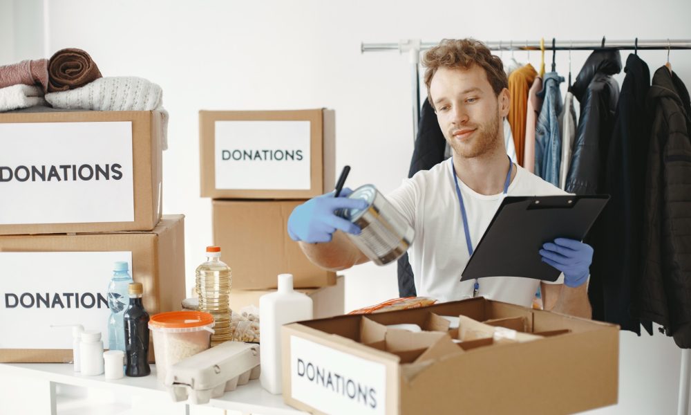 Volunteer packing donation boxes, illustrating UK businesses giving less to charity
