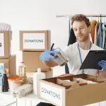 Volunteer packing donation boxes, illustrating UK businesses giving less to charity