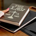 Law book with scales of justice on a lawyer's desk