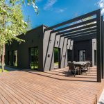 Modern house with a timber deck and outdoor dining area, one of the home improvements that could add value