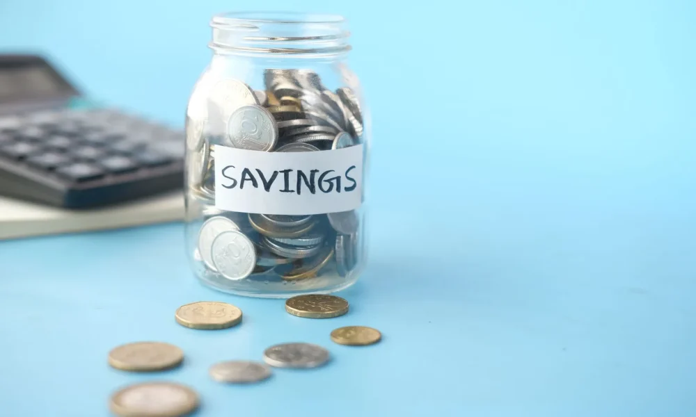 Savings jar of coins beside a calculator
