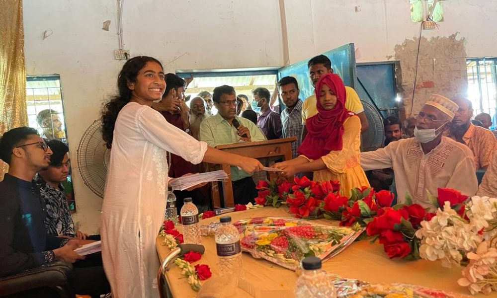 A student receives an education sponsorship from Mujjahid Huq at a ceremony in Bangladesh