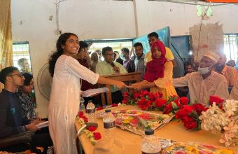 A student receives an education sponsorship from Mujjahid Huq at a ceremony in Bangladesh