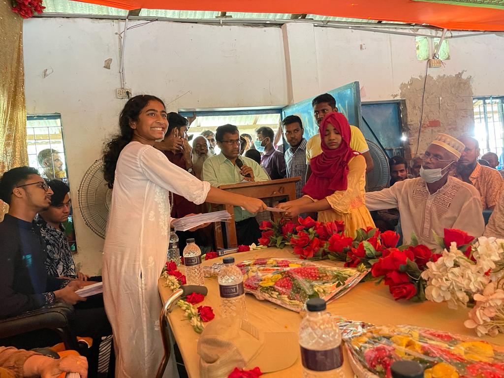 A student receives an education sponsorship from Mujjahid Huq at a ceremony in Bangladesh