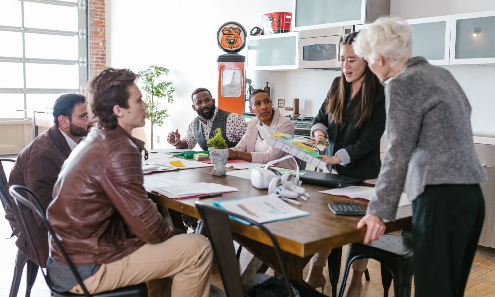 A health startup team reviewing plans with an investor around a table