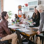 A health startup team reviewing plans with an investor around a table