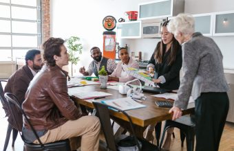 A health startup team reviewing plans with an investor around a table