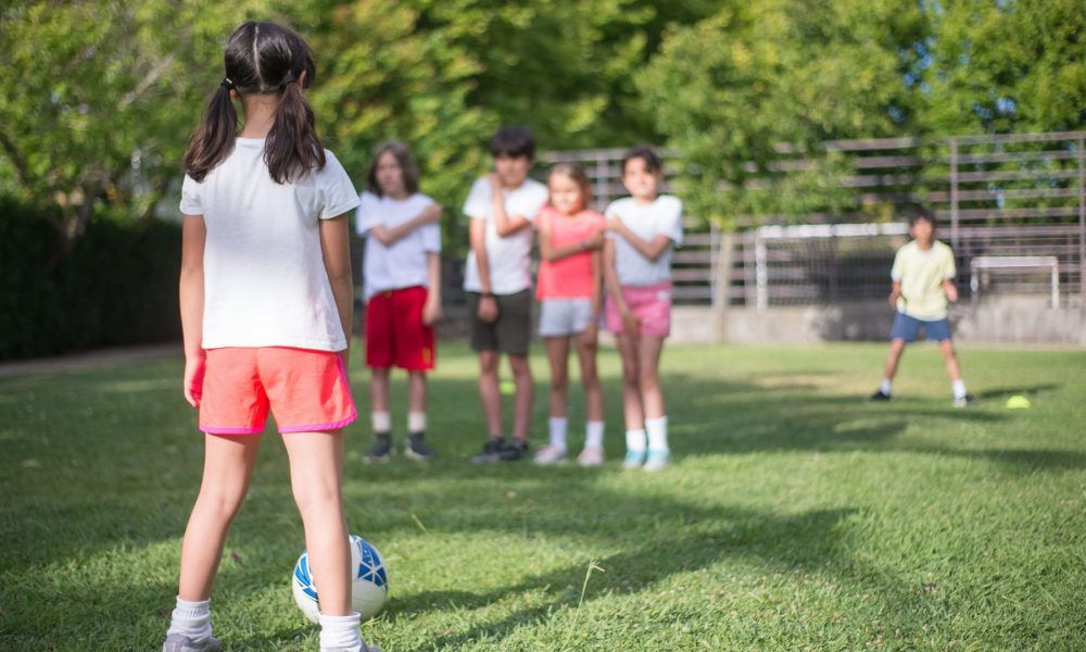 Children taking turns at a relaxed football session, the low-pressure play that supports youth mental wellness